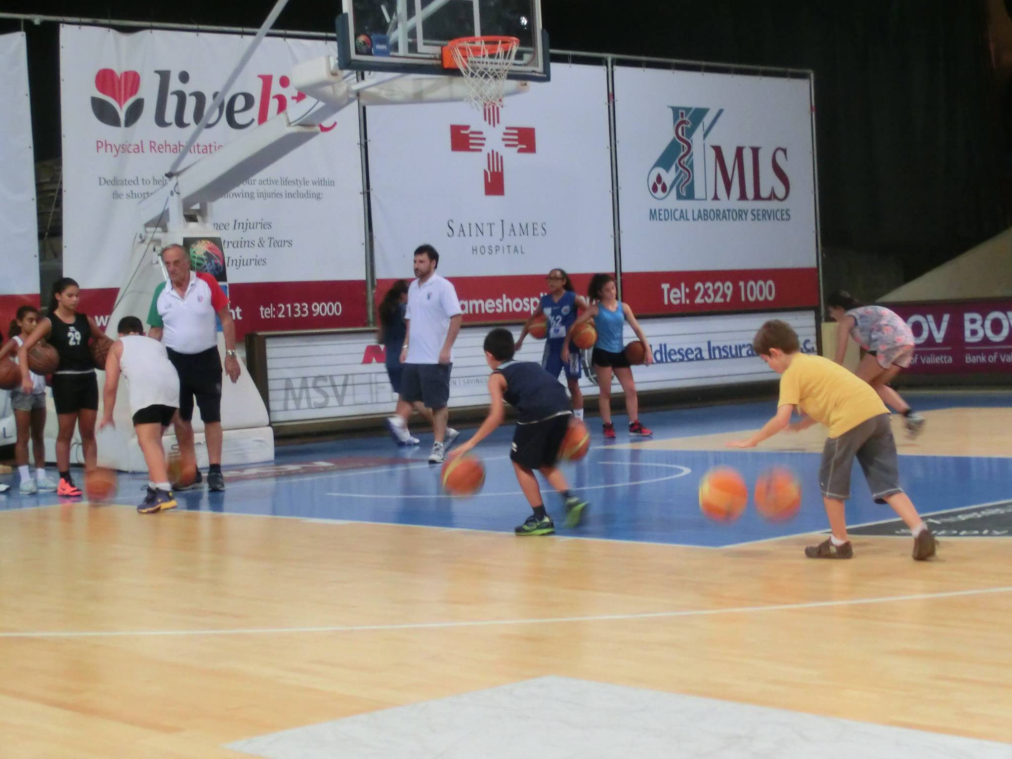 Giocatore di basket bambino che corre e schiaccia la palla bambino attivo  che si diverte a giocare all'aperto con il basket